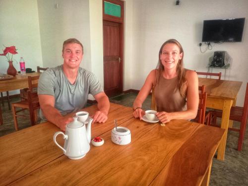 a man and a woman sitting at a wooden table at Yala wind in Tissamaharama