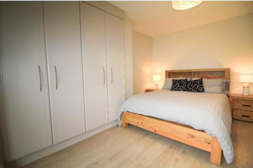 a bedroom with a bed and white cabinets at Stylish Spacious 4 Bedroom House in Galway