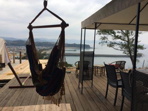 a hammock on a deck with a view of the water at Yamamizuki in Shimanto