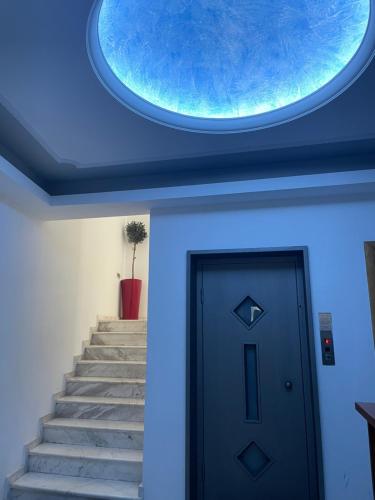 a blue ceiling with a round window above a door at Vythos Rooms in Paralion astros