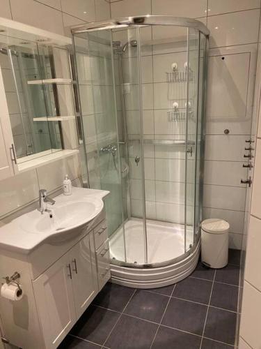 a white bathroom with a shower and a sink at Lovely apartment in Bergen in Bergen