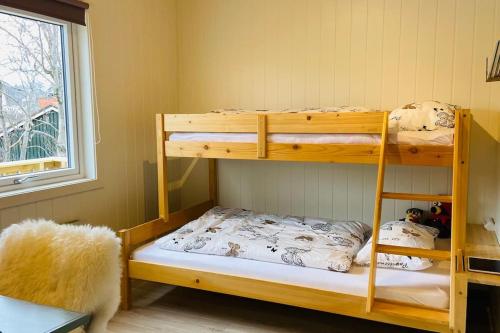 1 Schlafzimmer mit 2 Etagenbetten und einem Fenster in der Unterkunft Familyfriendly-modern, in the fishingtown Stamsund, with Sauna and Jacuzzi in Stamsund
