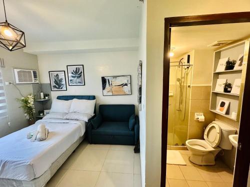 1 dormitorio con 1 cama y 1 silla azul en Studio Casa Mira Tower 2 en Cebú