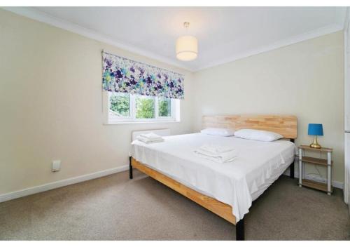 um quarto branco com uma cama grande e uma janela em Charming Uxbridge 3BR Home with Parking em Uxbridge