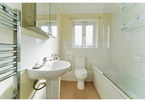Baño blanco con lavabo y aseo en Charming Uxbridge 3BR Home with Parking en Uxbridge