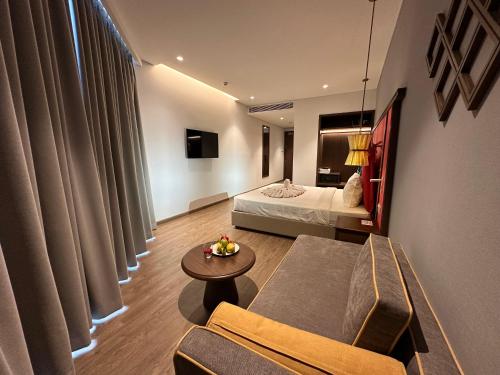 Habitación con sofá, cama y mesa. en APEC MANDALA CDT - Resort, en Phan Thiet