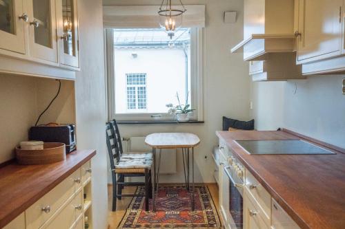 a kitchen with a counter and a stool and a window at Cosy Apartment in Frogner in Oslo