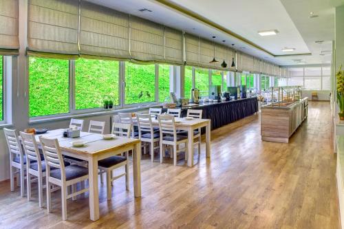 a restaurant with tables and chairs and a bar at Sanatorium GÓRNIK in Iwonicz-Zdrój