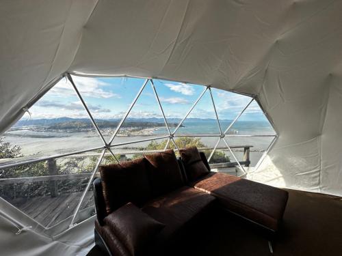 a couch in a tent with a large window at Yamamizuki in Shimanto
