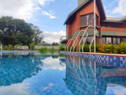a swimming pool in front of a house at Sadashiv Bungalow - Kudje,3BHK with swimming pool in Pune