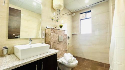 uma casa de banho com um lavatório e um WC em ZEN Suites - Golf Course Road Gurgaon em Gurgaon