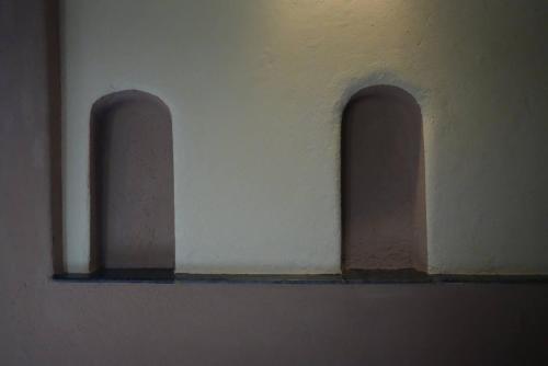 two arches on the side of a white wall at Khirni House in Māndu