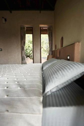 a large bed in a room with two windows at Khirni House in Māndu