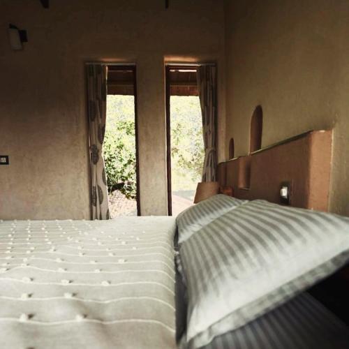a bedroom with a white bed and two windows at Khirni House in Māndu