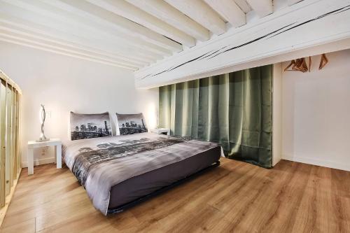- une grande chambre avec un grand lit et du parquet dans l'établissement Le somptueux saint-clair, à Caluire-et-Cuire