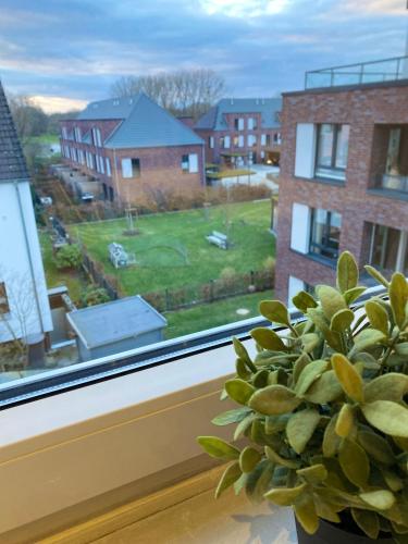 a plant sitting on a window sill with a view of a yard at Schöne Wohnung in charmanter Stadtvilla Messenähe in Hannover