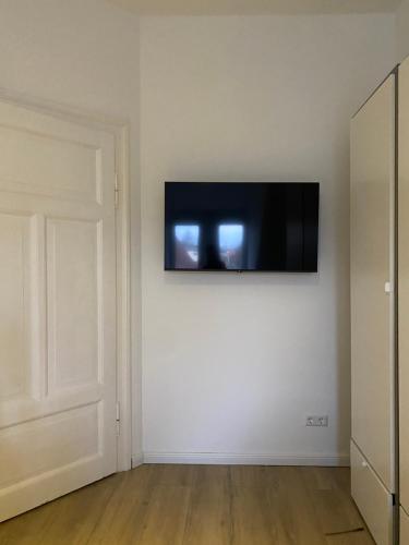 a flat screen tv on a white wall in a room at Schöne Wohnung in charmanter Stadtvilla Messenähe in Hannover