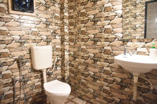 a stone bathroom with a toilet and a sink at Valerys Nest Bogmalo - Private villa near the beach and Dabolim airport in Bogmalo