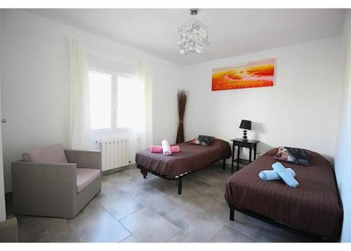 1 dormitorio con 2 camas, sofá y silla en Verano, en Benissa