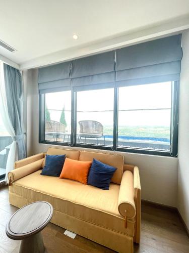 a couch in a living room with a large window at APEC MANDALA Condotel in Phan Thiet
