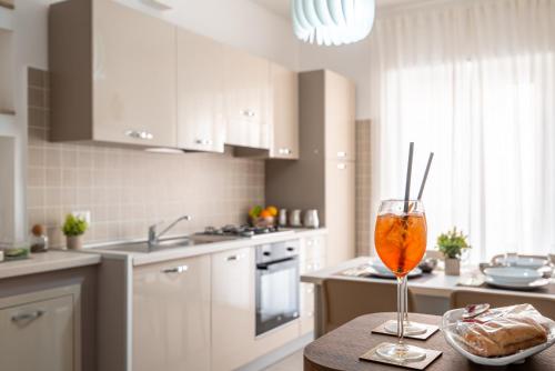 a kitchen with a table with a wine glass on it at KELIFOS Comfort Apartment in SantʼAgata di Militello