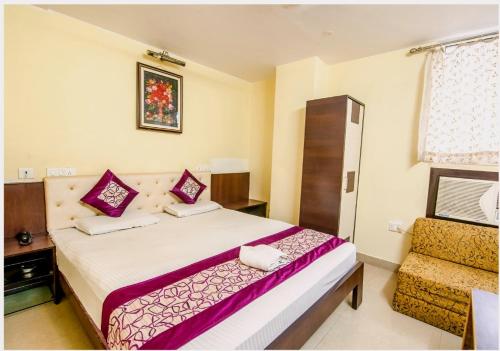 Habitación de hotel con cama y silla en Hotel Pearl by Revgrow360, en Ranchi
