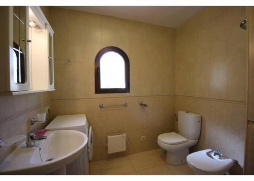 ein Bad mit einem Waschbecken, einem WC und einem Fenster in der Unterkunft Valet in Calpe