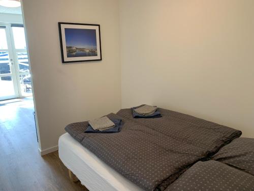 a bed in a room with a picture on the wall at Pakhuset Anholt in Anholt