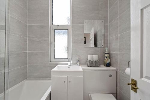 uma casa de banho branca com um lavatório e um chuveiro em Modern Flat on The Hoe w Private Parking em Plymouth
