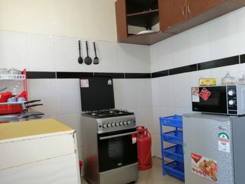 a kitchen with a stove and a refrigerator at Klimax Place in Kiambu
