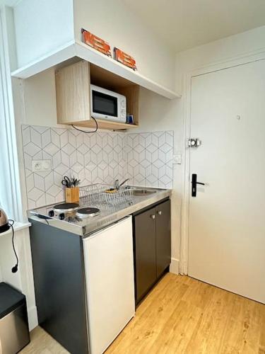 une cuisine avec un évier et une cuisinière four supérieur dans l'établissement Studio La Petite Montagne, à Quimper