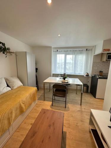 a room with a bed and a table and a kitchen at Studio La Petite Montagne in Quimper