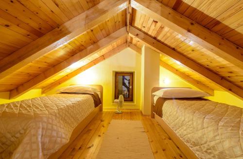 two beds in a room with wooden ceilings at Vila Donna Apartments in Trogir