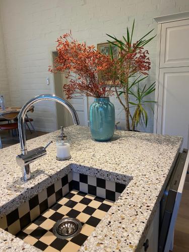 a kitchen counter with a vase with flowers in it at Rustiek vakantiehuis in 't groen in Lier