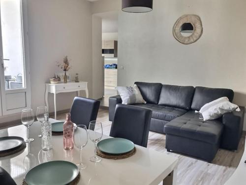- un salon avec un canapé et une table avec des verres à vin dans l'établissement Appartement avec terrasse centre de la Bastide, à Carcassonne