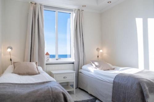 1 dormitorio con 2 camas y ventana grande en Lägenhet med vacker havsutsikt, en Visby