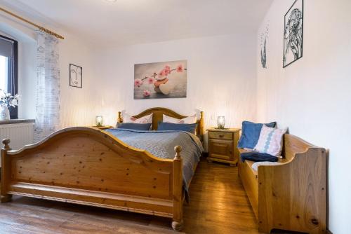 a bedroom with a wooden bed and a chair at Buchhaus Vier - Mittelgeschoss in Kirchenlamitz