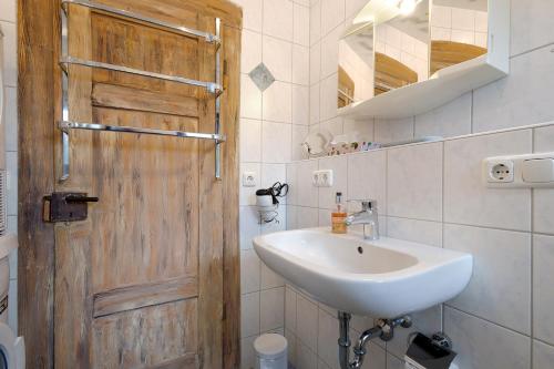 a bathroom with a sink and a wooden door at Buchhaus Vier - Mittelgeschoss in Kirchenlamitz