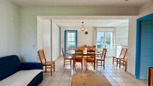 ein Esszimmer und ein Wohnzimmer mit einem Tisch und Stühlen in der Unterkunft Pommeraie et Eglantines in Quend