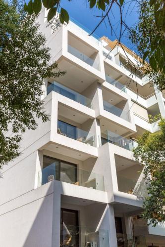 ein weißes Gebäude mit Balkon auf der Seite in der Unterkunft Cubes Living Athens Goudi in Athen