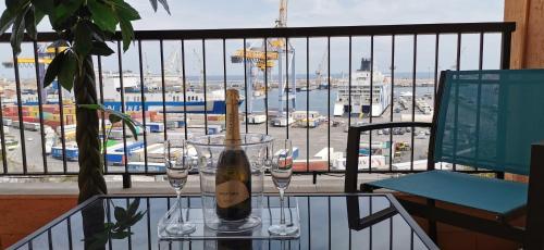 eine Flasche Wein auf dem Tisch mit Gläsern auf dem Balkon in der Unterkunft Port Side Elegance Palermo in Palermo
