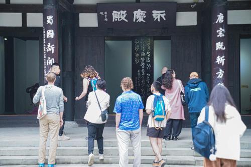 a group of people standing on steps outside a building at Chengdu Local Tea Hostel - Short Walk To Taikooli - Chill & Social Coffee Lounge - Metro downstairs - Free Activities - Friendly English Speaking Staff - Tibet, Panda, Buddha & Snow Mountain Tours in Chengdu