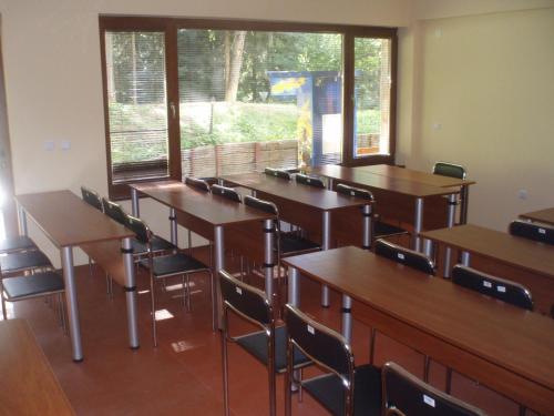 una clase con escritorios, sillas y una ventana en Villa Ibar, en Borovets