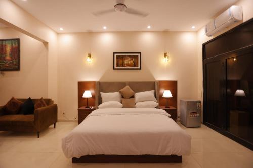 ein Schlafzimmer mit einem großen Bett und einem Sofa in der Unterkunft A One Hotel Clifton in Karatschi