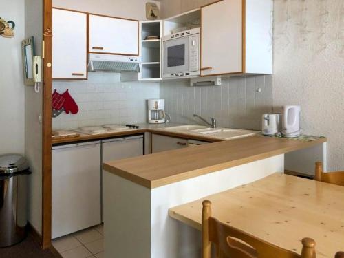 a kitchen with white cabinets and a wooden counter top at FOLYERE 17 La Tania in La Tania