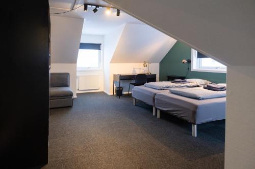 a bedroom with two beds and a desk and a chair at Kulukis Downtown Hostel in Nuuk