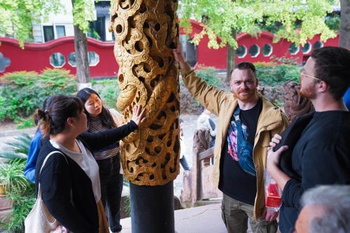 a group of people standing around a statue of a person in a costume at Chengdu Local Tea Hostel - Short Walk To Taikooli - Chill & Social Coffee Lounge - Metro downstairs - Free Activities - Friendly English Speaking Staff - Tibet, Panda, Buddha & Snow Mountain Tours in Chengdu