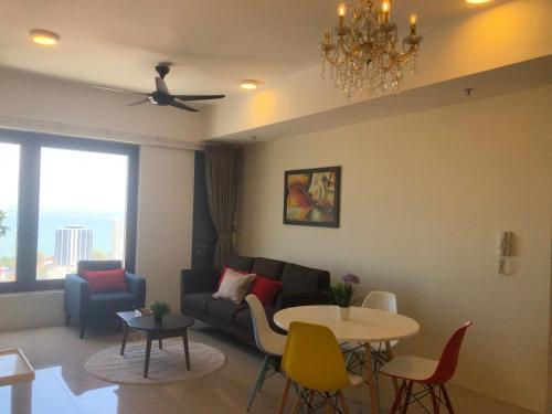 ein Wohnzimmer mit einem Sofa und einem Tisch in der Unterkunft Tropicana 218 Macalister Netflix Unit by Blue Sky Holidays in George Town