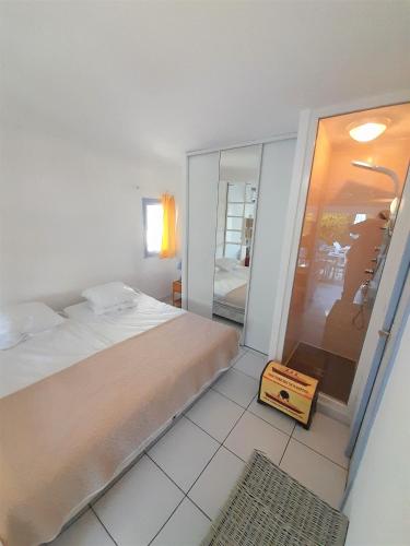 une chambre avec un lit et une grande fenêtre en verre dans l'établissement Villa Village Naturiste Tabou, au Cap d'Agde