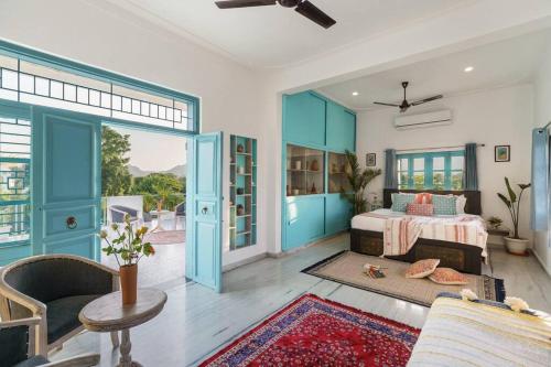 a bedroom with blue doors and a bed and a couch at Thaharo 2 BHK Luxurious Villa in Udaipur in Thūr